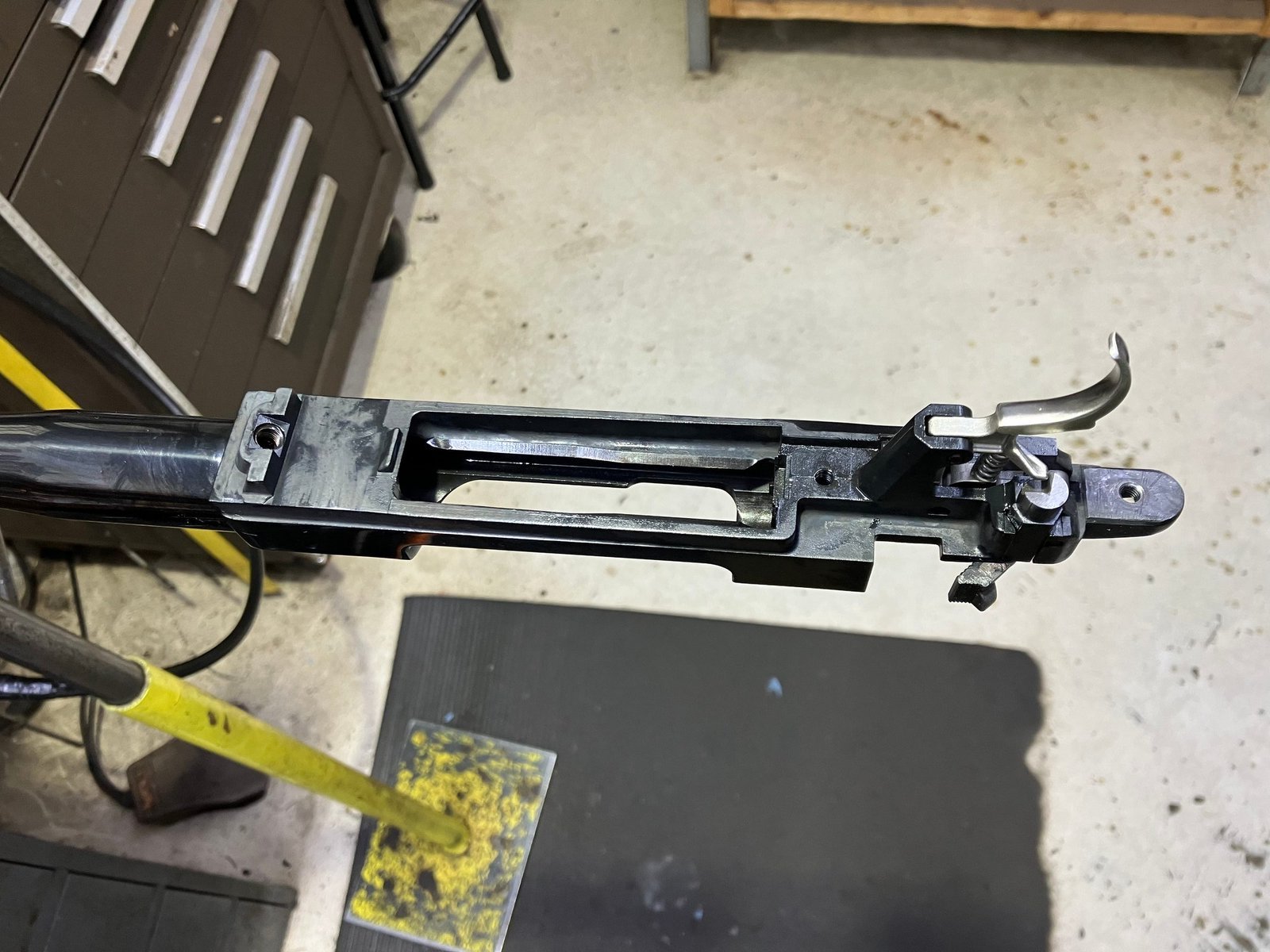 Barreled bolt action in a shop vise after it was taken out of the stock, trigger still attached
