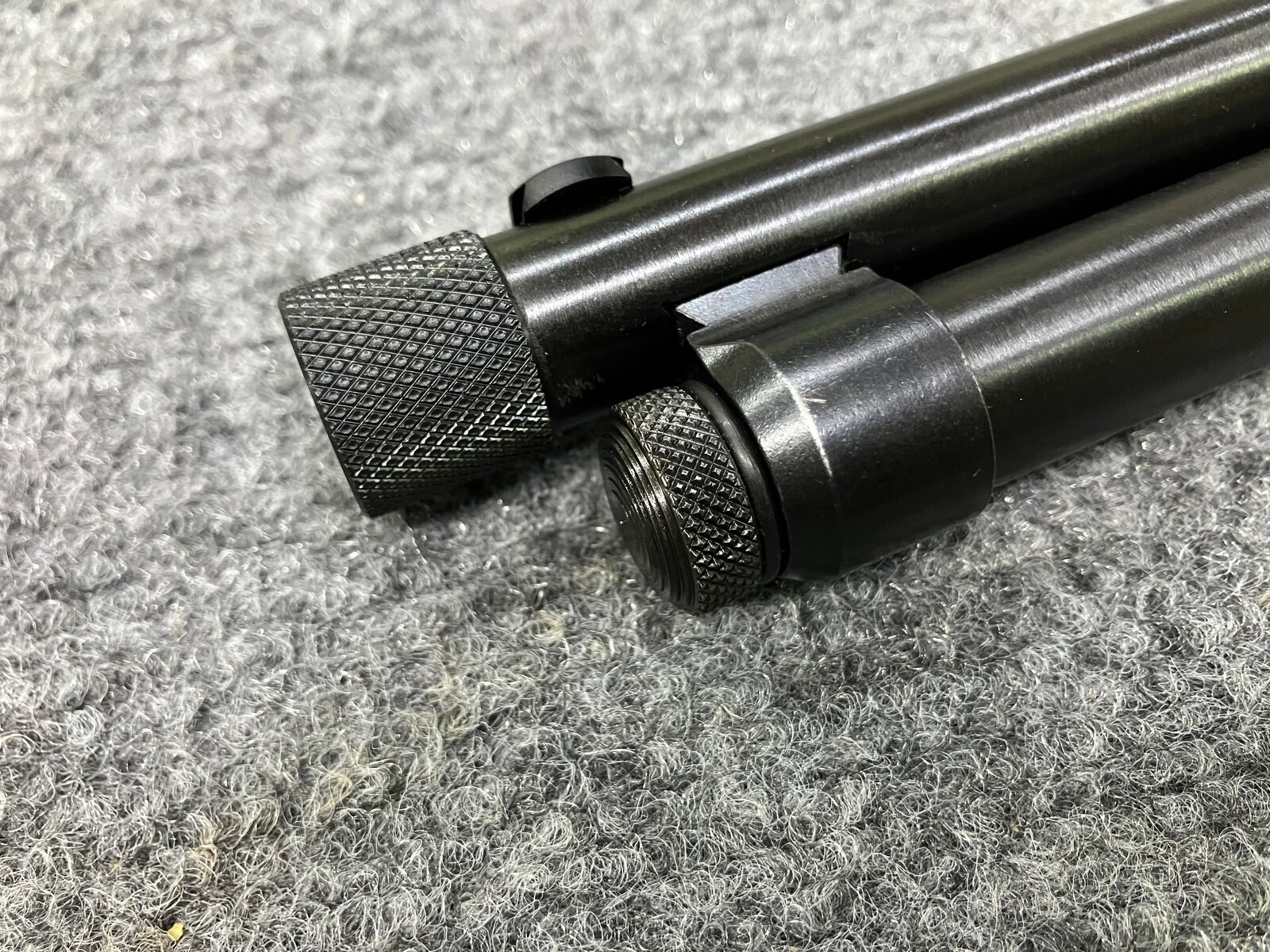 Muzzle of a tube-fed firearm after threading, with a knurled thread protector and a shortened magazine cap nut
