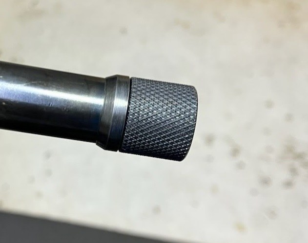 Finished cold-blued shoulder-expanding collar with a knurled thread protector installed